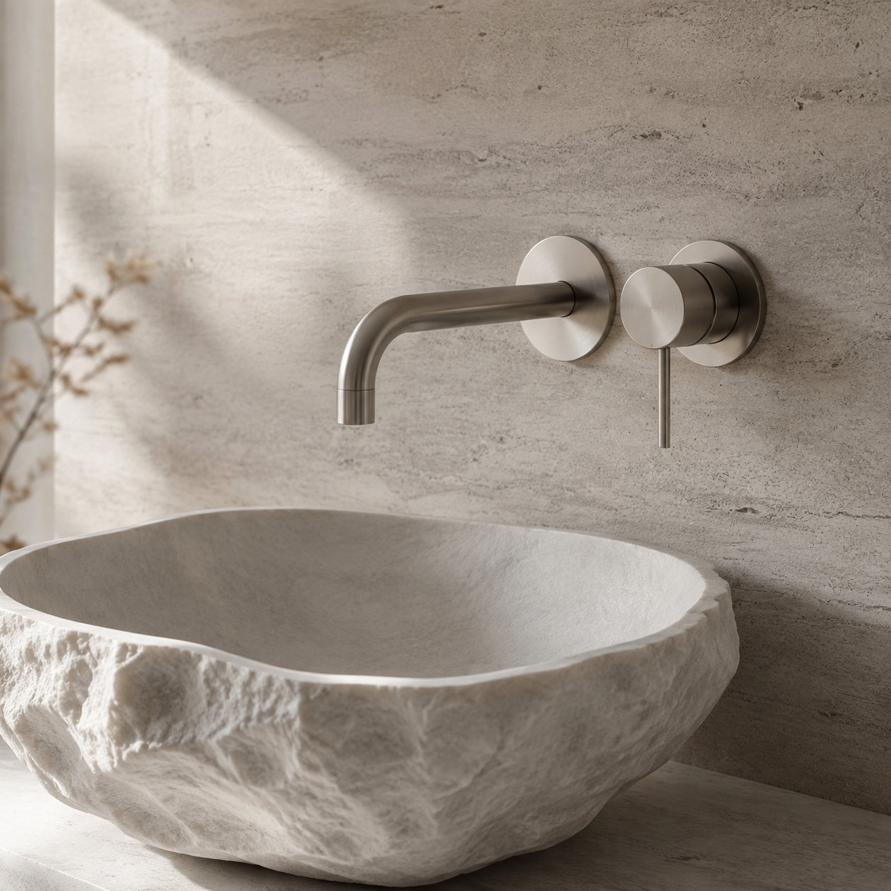 Detail of a brushed metal basin faucet in a refined interior